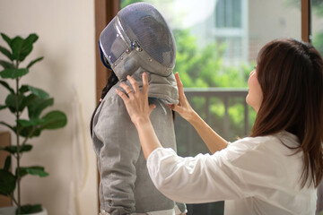 The mother takes care of and shows love to her daughter, a fencing athlete, caring for growing child concept.