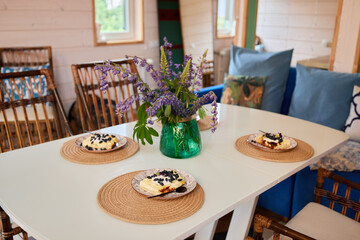 A Charming Dining Table Set with Beautiful Flowers and Delicious, Tasty Desserts