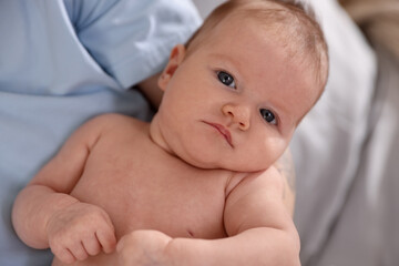Mother with her cute newborn baby on bed at home, above view