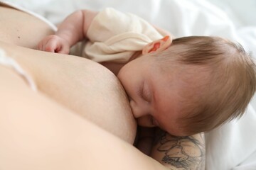 Mother breastfeeding her newborn baby indoors, above view