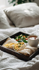 Breakfast features warm scrambled eggs wrapped in soft tortillas, placed on a wooden tray alongside a steaming cup of coffee in a cozy, inviting bedroom