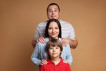 Portrait of happy family on brown background