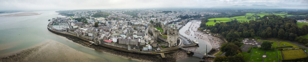 Aerial panoramic view of Caernarfon, featuring its historic castle, the town, river, and...