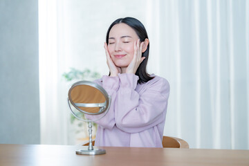 部屋で鏡を見る女性
