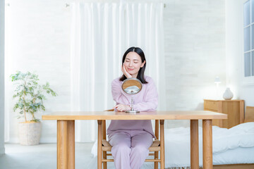 部屋で鏡を見る女性