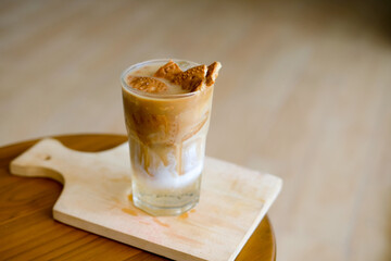 
Iced coffee with a creative biscuit topping, perfectly chilled on a wooden table, ideal for cafes,...