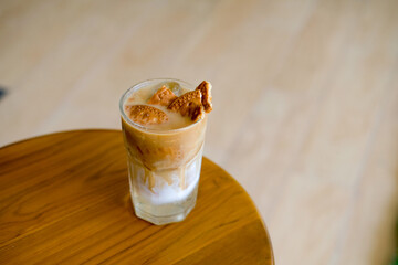 
Iced coffee with a creative biscuit topping, perfectly chilled on a wooden table, ideal for cafes,...