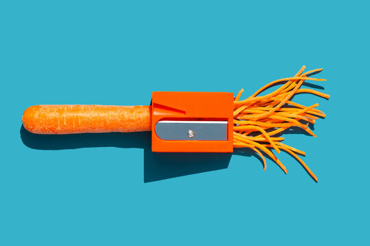 Carrot pencil sharpener on bright blue background