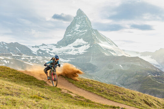 Cyclist navigating mountain trail in the scenic Alps