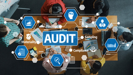 A diverse group of professionals collaborates around a table during an audit session, reviewing...
