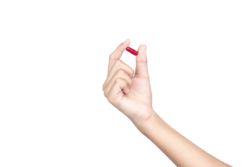 A female hand holding up a red medicine capsule or pill for health and wellness treatment, isolated on white background with clipping path.