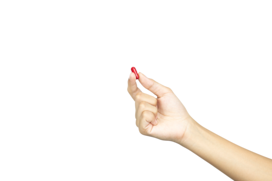 A female hand holding up a red medicine capsule or pill. Concept of choice and health treatment, isolated on white background with clipping path.