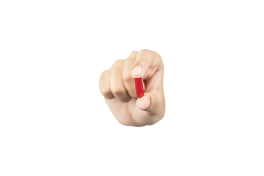 hand holding and showing a red medicine capsule or pill forward to the camera for treatment, isolated on white background with clipping path.