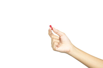 A female hand holding up a red medicine capsule or pill. Concept of choice and health treatment, isolated on white background with clipping path.