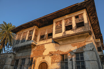 An old house in the Kaleici district of Antalya. A house in Antalya, located in the Muratpasha area. A stone house and a palm tree. An old house in need of restoration.