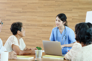Caring nurse in blue uniform engaging with elderly patients during health consultation, captured in...