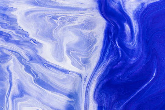 Abstract blue acrylic paint background with swirling patterns