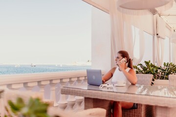 Woman coffee cafe laptop sea. Modern businessman in white uniform working on laptop in coffee shop. Woman sitting at a coffee shop with mobile phone drinking coffee.
