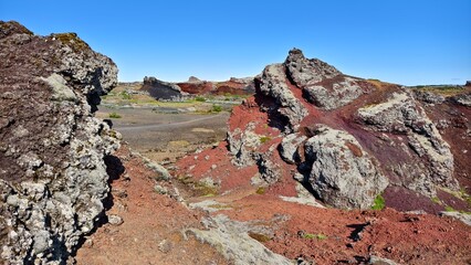 Red volcanic rock formations formed by lava in Iceland, abstract landscape