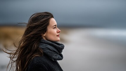 A woman with long brown hair standing on a beach