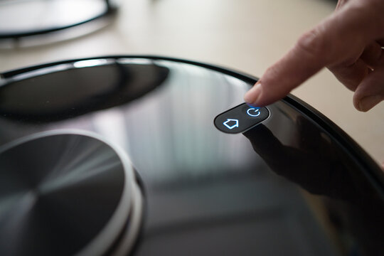 Senior man using smart vacuum to clean home