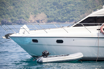 Rubber boat,dinghy or inflatable boat tie with big luxury yacht.