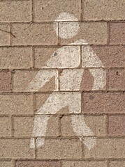 Icono de peatón pintado con pintura blanca en suelo de adoquines en camino peatonal 