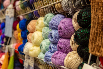 Multi-colored yarn for creativity and knitting in the shop window. Soft focus. Materials for...