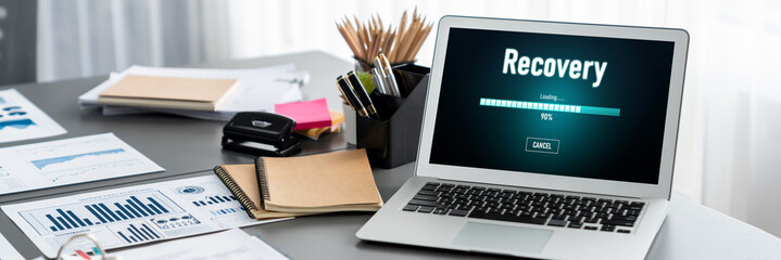 Data analysis dashboard display on laptop screen on office table with financial papers by Fintech...
