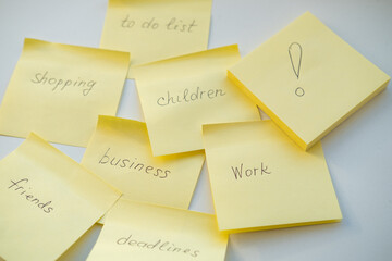 Notes reminders of yellow colored stickers with text on the table. Many unfulfilled tasks,...