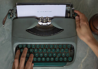 Hands typing on a vintage typewriter, crafting the message the best is yet to come, fueling...