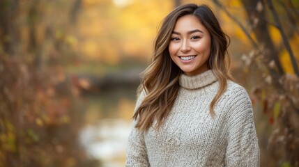 Portrait of a happy young woman in autumn, smiling while enjoying the scenic fall foliage and soft golden light.