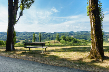 Eine Rastbank zwischen zwei Bäumen mit herrlicher Aussicht in die Steiermark