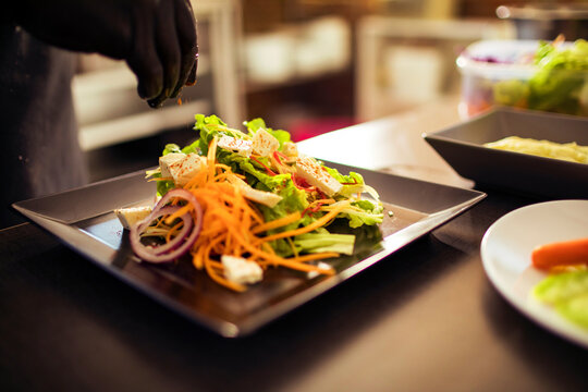 Naklejki Chef plating gourmet meal with precision in fine dining restaurant