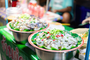 Fresh traditional street food display with colorful vegetables and spices on a busy market stall...