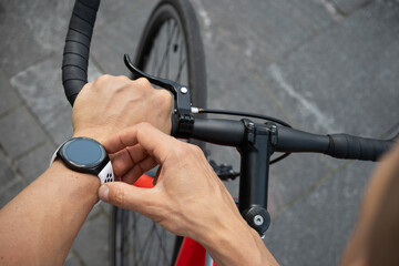Athlete cyclist checking distance, pulse or fitness progress in apps after riding. Close up man...