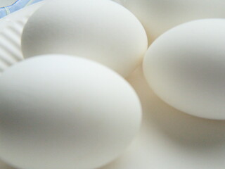 White chicken eggs on a white background. Closeup