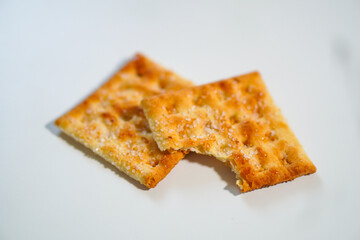 Two wheat biscuits with one half eaten on a white background