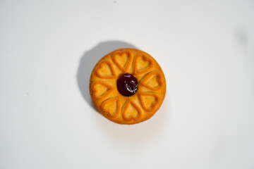 One biscuit with grape jam, white background. top view photo