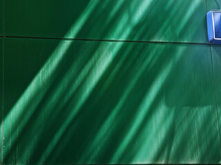 Dramatic light rays falling on the green colored wall