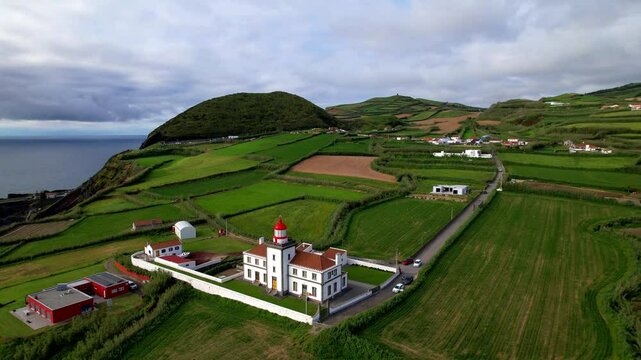 Idyllic nature scenery of Azores island. Drone view of picturesque landscape with lighthouse Farol da Ferraria and green pastures. San Miguel island, Portugal