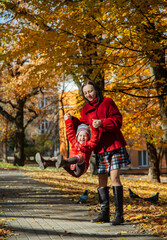 Fototapeta premium Mother and daughter enjoying sunny autumn day in park. Family togetherness and fall leisure concept