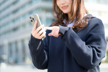 スマホを指差す日本人女子高生