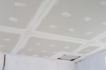 Smooth gypsum board ceiling edges taped plastered during interior building renovation exposed...
