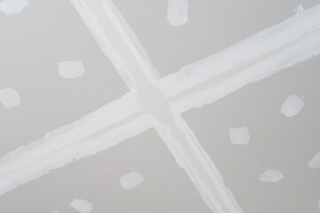 Gypsum board ceiling undergoing interior building renovation smooth plastering on edges....