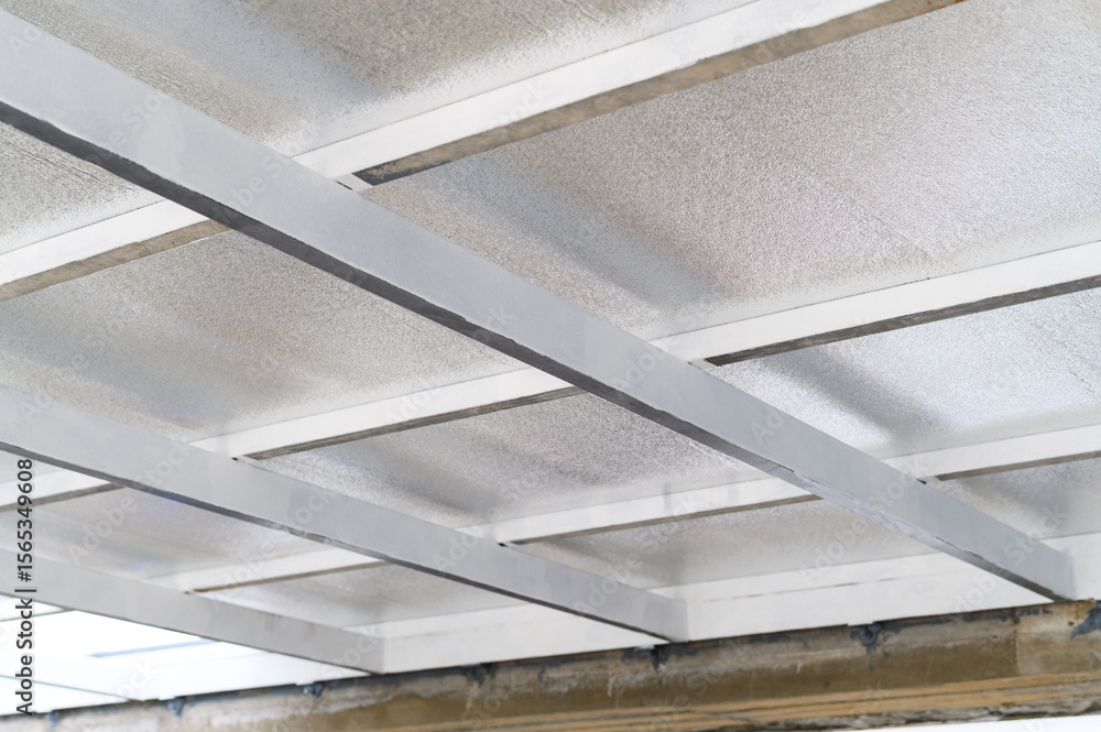 Poster close up view of ceiling structure with metal supports and insulating sheets. these panels likely co