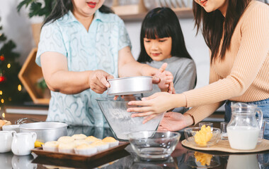 Grandmother cooking with daughter and mother family fun at home kitchen