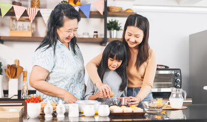 Grandmother cooking with daughter and mother family fun at home kitchen