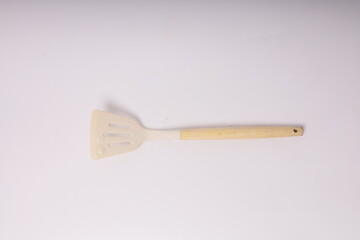 Kitchen White spatula on isolated white background. White silicone spatula with wooden handle. Cooking utensil used for cooking food in the kitchen of every house.