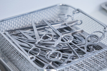 Top view of polished medical instruments, including forceps and clamps, meticulously organized in a...